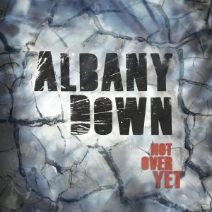 A grey/white piece of salt plain with a large circular outline made of burn marks. In the middle is the Albany Down wordmark, with Not Over Yet below and to the right.