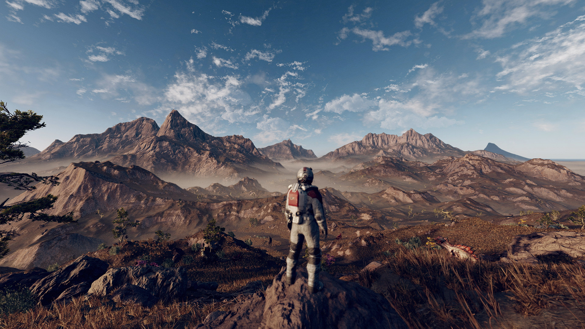 An astronaut viewed from behind in a spacesuit stands on a rocky outcrop, looking into the distance. The landscape is rocky and barren.
