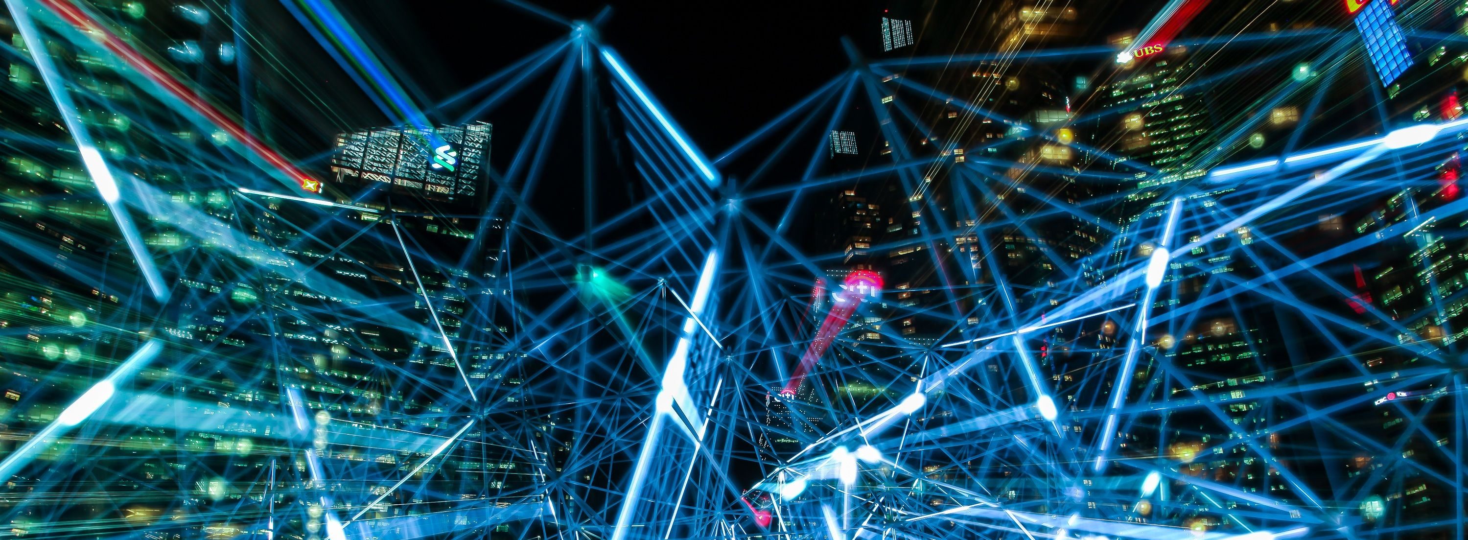 A neon-lit city barely visible behind nodes connected by blue lasers.