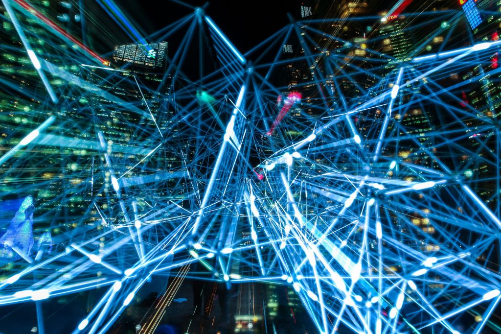 A neon-lit city barely visible behind nodes connected by blue lasers.